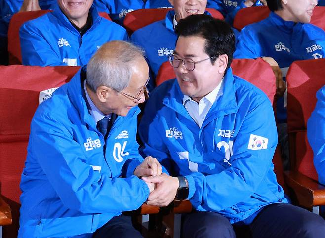 더불어민주당 윤여준, 박찬대 상임총괄선대위원장이 3일 국회의원회관 개표상황실에서 제21대 대통령선거 지상파 출구조사 결과에서 이재명 후보가 51.7%로 앞서는 것으로 발표되자 기뻐하며 악수하고 있다. (사진=연합뉴스)