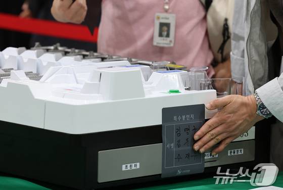 21대 대통령선거를 하루 앞둔 2일 대전 유성구 대전컨벤션센터에 마련된 개표소에서 유성구선관위 관계자들이 개표 준비 상황을 점검한 뒤 투표지 분류기에 봉인지를 부착하고 있다. 2025.6.2/뉴스1 ⓒ News1 김기태 기자