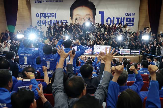 더불어민주당 박찬대, 윤여준 상임총괄선대위원장을 비롯한 선대위 관계자들이 3일 국회의원회관 개표상황실에서 제21대 대통령선거 지상파 출구조사 결과에서 이재명 후보가 51.7%로 앞서는 것으로 발표되자 환호하고 있다. /연합뉴스