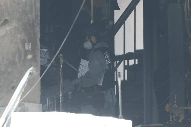 소방재난본부 관계자가 3일 오전 화재가 발생한 서울 중구 신당동의 한 봉제공장에서 잔불울 정리하고 있다. 뉴스1