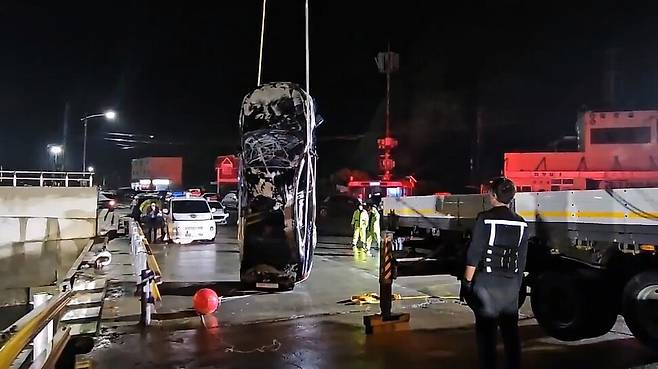 목포해경이 2일 밤 전남 진도군 진도항 인근에서 일가족이 탄 채로 바다에 빠진 차량을 인양하고 있다. 광주북부경찰은 가족 3명을 숨지게 한 혐의로 40대 남성을 광주에서 붙잡아 조사 중이다. 목포해경 제공