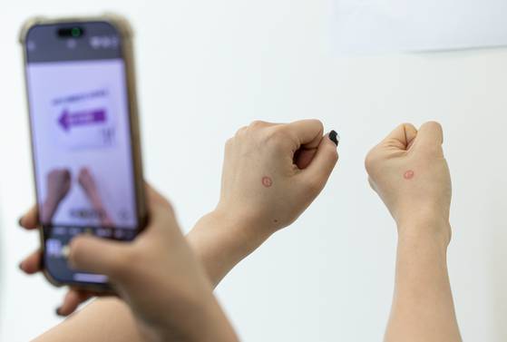 Voters take photos after casting their ballots at an early voting station set up in Hwaseong, Gyeonggi, on May 29. [NEWS1]
