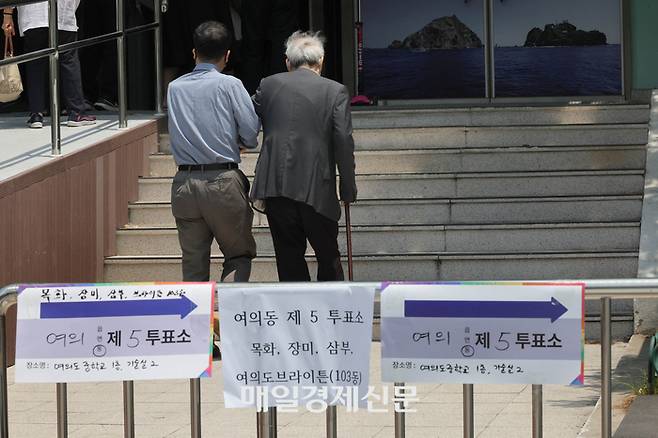 제21대 대통령선거일인 3일 서울 영등포구 여의도중학교에 마련된 여의도제4투표소에서 노인이 가족의 도움을 받아 투표소로 들어가고 있다. 2025.6.3[이충우 기자]