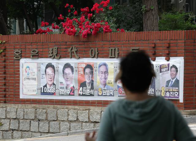제21대 대통령 선거를 하루 앞둔 2일 서울 한 아파트 장미 화단 아래에 대선 후보 벽보가 붙어 있다. 연합뉴스