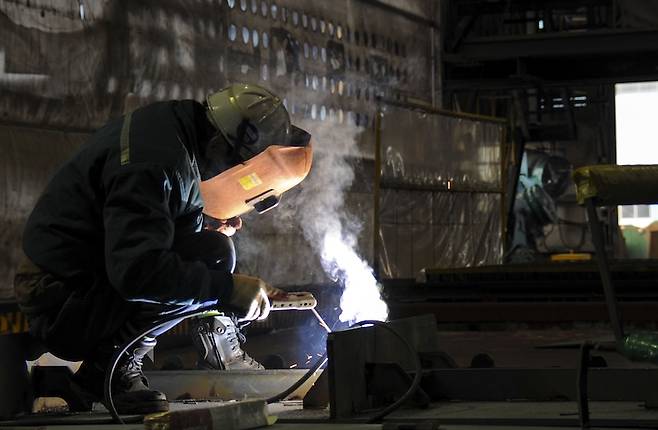 전남 영암 대불산업단지에서 한 근로자가 용접작업을 하고 있다. 조선업계는 호황인데, 이곳 근로자들이 박봉에 시달리는 원인은 기업의 수요독점에 있다. [사진 | 뉴시스]