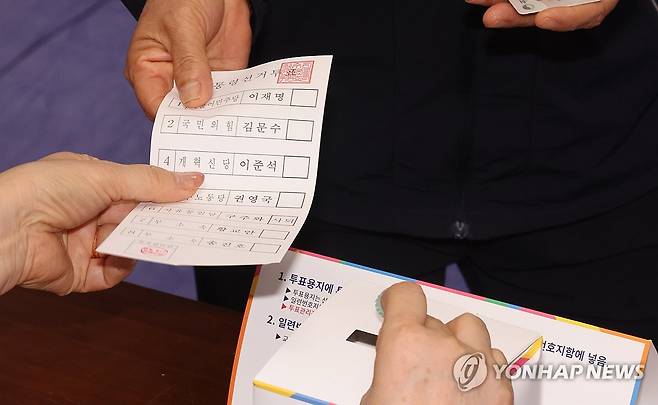 제21대 대선 본투표 시작 (제주=연합뉴스) 박지호 기자 = 제21대 대통령선거일인 3일 오전 제주시 연동 제1투표소가 마련된 제주도의회 의원회관에서 한 유권자가 투표용지를 배부받고 있다. 2025.6.3 jihopark@yna.co.kr