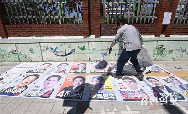 제21대 대통령선거 다음 날인 4일 오후 수원시 영통구 동수원중학교 담장에서 벽보 철거업체 관계자가 선거 벽보를 철거하고 있다. 2025.6.4 /최은성기자 ces7198@kyeongin.com