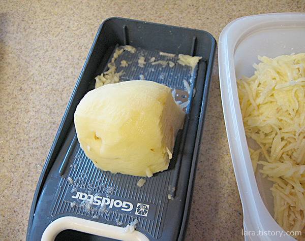 채칼에 감자를 써는 모습