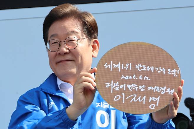 이재명 대통령이 지난달 12일 경기 화성시 동탄 센트럴파크 음악분수중앙광장에서 '세계 1위 반도체 강국 도약!'이라고 쓴 반도체 웨이퍼를 들어 보이고 있다./공동취재단