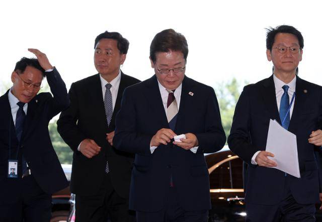 이재명 대통령이 4일 서울 용산 대통령실에 도착해 집무실로 이동하면서 착용했던 무선이어폰을 충전케이스에 넣고 있다. 왕태석 선임기자