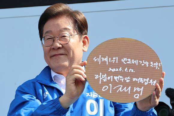이재명 대통령이(당시 대선 후보)이 6·3 대통령선거 공식 선거운동 첫날인 지난 5월 12일 경기 화성시 동탄 센트럴파크 음악분수중앙광장 유세장에서 '세계1위 반도체 강국 도약!'이라고 쓰고 서명한 반도체 웨이퍼를 들어보이고 있다. [사진=연합뉴스]