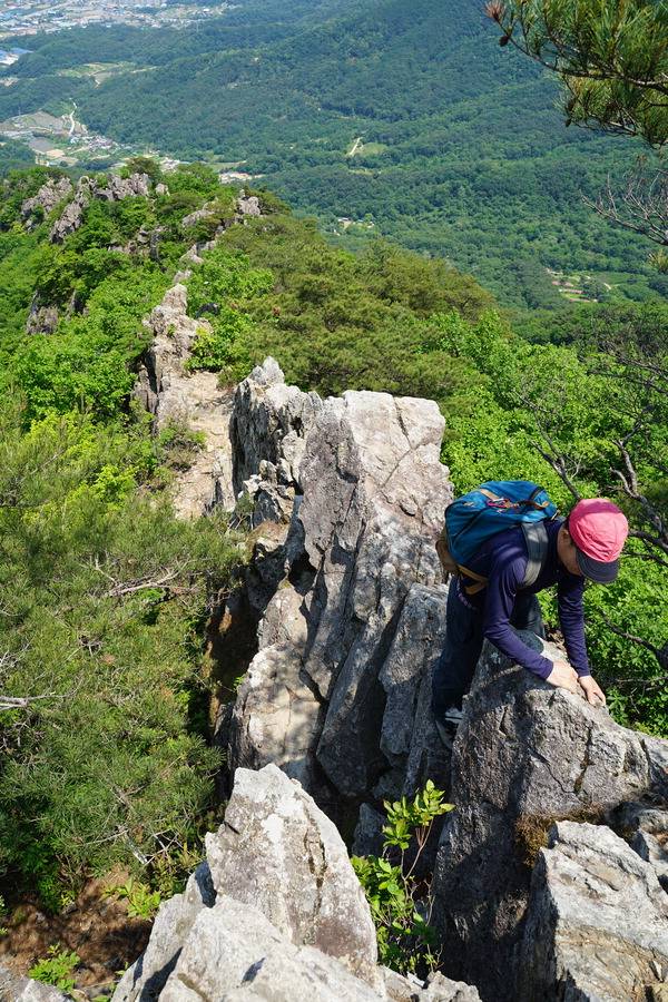 칼바위를 올라서는 취재팀 뒤로 넘어온 바윗길이 꼬리를 물고 있다.