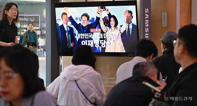 4일 오전 서울 용산구 서울역 대합실에서 시민들이 이재명 대통령 당선 관련 뉴스를 시청하고 있다. 임세준 기자