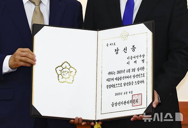 [과천=뉴시스] 김근수 기자 = 노태악(왼쪽) 중앙선거관리위원회 위원장이 4일 오전 경기 과천시 중앙선거관리위원회 회의실에서 열린 제21대 대통령 당선증 교부식에서 박찬대 더불어민주당 상임 총괄선거대책위원장에게 당선증을 전달하고 기념촬영을 하고 있다. 2025.06.04. ks@newsis.com