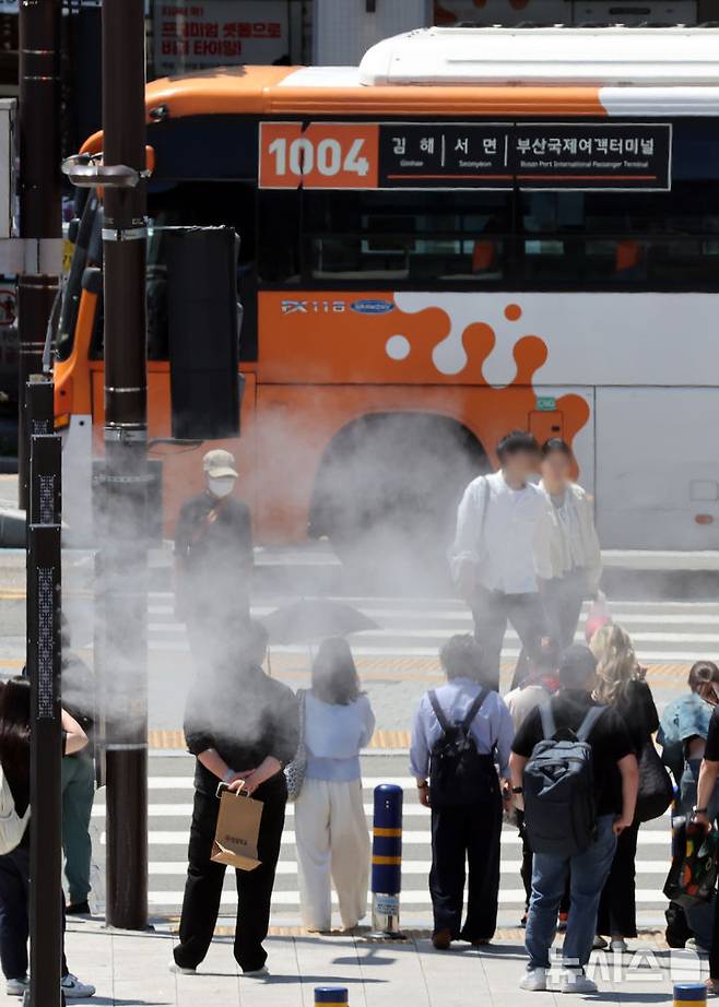 [부산=뉴시스] 하경민 기자 = 무더운 날씨를 보인 4일 부산 동구 부산역 광장 횡단보도 앞에서 신호를 기다리던 시민과 관광객들이 시원한 쿨링포그를 맞고 있다. 2025.06.04. yulnetphoto@newsis.com