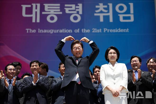 [서울=뉴시스] 조성우 기자 = 이재명 대통령 내외가 4일 오전 서울 여의도 국회 로텐더홀에서 취임 선서를 마치고 나와 잔디광장에 모인 시민들을 향해 하트를 만들어 보이고 있다. 2025.06.04. xconfind@newsis.com