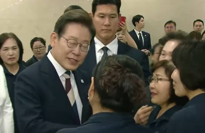 국회 청소 노동자와 인사 나누는 이재명 대통령. 연합TV 보도화면 캡처