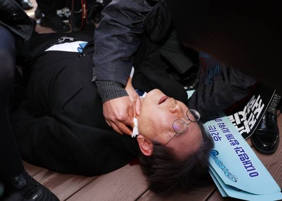 이재명 21대 대통령 당선인은 숱한 위기를 넘기며 굴곡진 정치 인생을 이어 왔다. 사진은 이 당선인이 더불어민주당 대표를 지내던 지난해 1월 부산 강서구 가덕신공항 건설 부지를 둘러보다가 피습을 당해 병원 호송을 기다리는 모습. 부산 연합뉴스