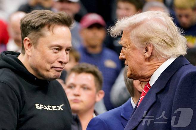 일론 머스크 테슬라 최고경영자(CEO)가 2025년 3월 22일 미국 펜실베이니아주 필라델피아에서 열린 NCAA 남자 레슬링 챔피언십에 참석한 도널드 트럼프 미국 대통령을 맞이하고 있다.  ⓒ 로이터=뉴스1 ⓒ News1 권영미 기자
