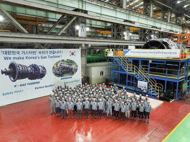 두산에너빌리티 창원 본사에 구축한 가스터빈 전용 시험장에서 개최된 380MW급 가스터빈 정격부하 성능시험 성공 기념식에서 정연인 부회장, 손승우 파워서비스BG장 등 주요 임직원이 기념사진을 촬영하고 있다. 두산에너빌리티