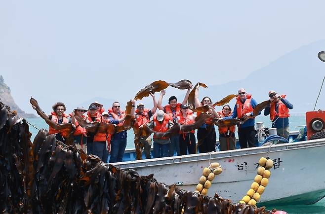 지난 2일 전남 완도 해조류 양식장 찾은 세계자연기금(WWF), 미국, 포르투갈 해조류 산업 관계자들이 기념촬영을 하고 있다. 완도군 제공