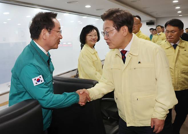 President Lee Jae-myung, right, shakes hands with Incheon Mayor Yoo Jeong-bok at the start of his first National Security Council meeting at the presidential office in Yongsan District, central Seoul, on June 5. [YONHAP]