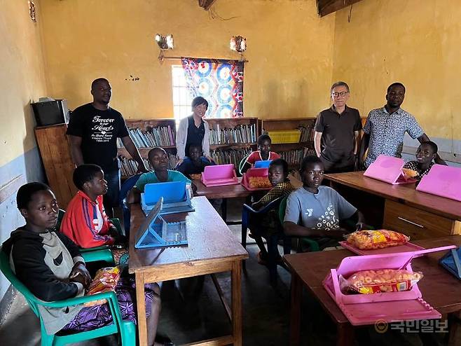 강 선교사와 주 선교사가 치소모아동센터 한쪽에 마련된 도서관에서 교사와 아이들과 함께 사진을 찍은 모습.