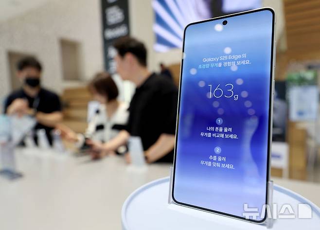 [서울=뉴시스] 김진아 기자 = 삼성전자가 초슬림 스마트폰 갤럭시 S25 엣지를 국내에 출시한 23일 서울 마포구 삼성스토어 홍대에서 시민들이 갤럭시 S25 엣지를 살펴보고 있다.  갤럭시 S25 엣지는 역대 갤럭시 S시리즈 중 가장 얇은 디자인에도 견고한 내구성을 갖춘 게 특징이다. 5.8㎜ 두께와 163g 무게로 초슬림·초경량 디자인을 구현했다. 2025.05.23. bluesoda@newsis.com