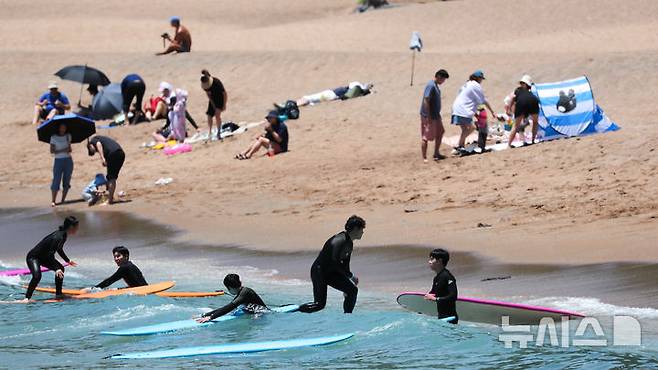 [서귀포=뉴시스] 우장호 기자 = 여름 날씨를 보인 5일 제주 서귀포시 중문색달해수욕장에서 물놀이객이 서핑을 배우며 즐거운 시간을 보내고 있다. 2025.06.05. woo1223@newsis.com