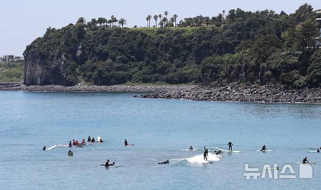 [서귀포=뉴시스] 우장호 기자 = 여름 날씨를 보인 5일 제주 서귀포시 중문색달해수욕장에서 물놀이객이 서핑을 배우며 즐거운 시간을 보내고 있다. 2025.06.05. woo1223@newsis.com