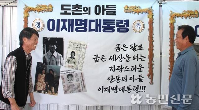 경북 안동시 예안면 도촌리 이재호 이장(오른쪽)과 주민 김기선씨가 마을회관에 설치한 이재명 대통령 당선 축하 펼침막을 보며 환하게 웃고 있다.