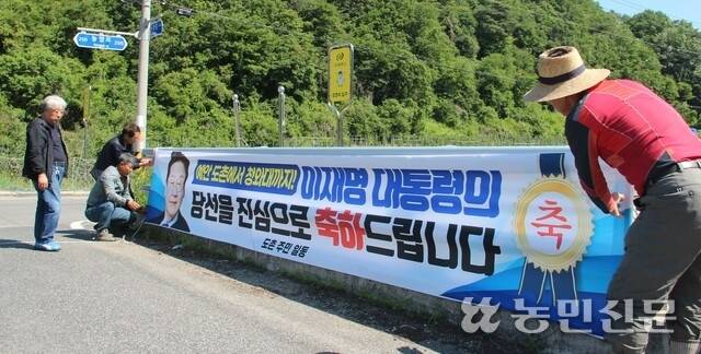 경북 안동시 예안면 도촌리 주민들이 4일 마을 입구에 이재명 대통령 당선 축하 현수막을 설치하고 있다.