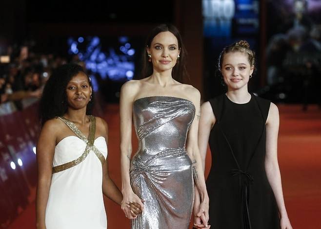 안젤리나 졸리의 자녀 샤일로 졸리가 지난 달 29일 한 패션행사에서 자신을 예명인&nbsp;시 졸리(Shi Jolie)로 소개했다. 사진은 안젤리나 졸리가 딸 샤일로 졸리(오른쪽), 자하라 졸리와 함께 2021년 10월 24일 이탈리아 로마에서 개최된 제16회 로마영화제 '이터널스' 시사회에 참석해 포토 타임을 갖는 모습. 연합