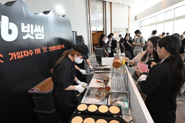 5일 서울 송파구 시그니엘 서울에서 열린 비트코인 서울 2025에 마련된 빗썸 부스에서 참가자들이 이벤트에 참여해 '비트코인 빵'을 받고 있다. 조태형 기자 2025.06.05