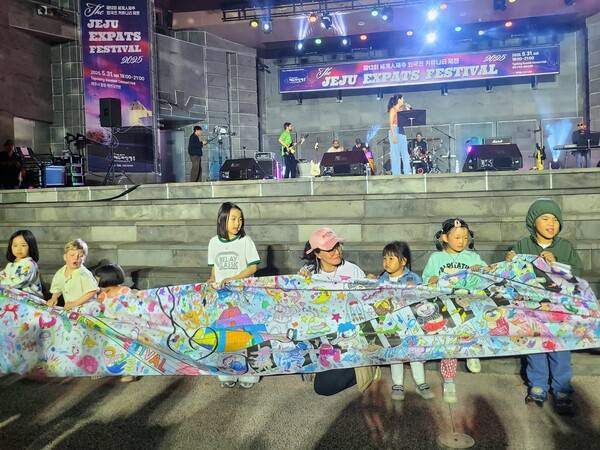 특별프로그램으로 진행된 세계문화미술체험에 참여한 거주 외국인 자녀들이 손수 제작한 플래카드를 들어보이고 있다.