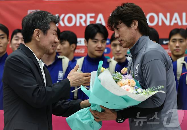 홍명보 감독이 6일 이라크와 북중미 월드컵 예선경기를 마치고 인천국제공항 제1터미널을 통해 귀국하며 정몽규 대한축구협회장에게 꽃을 받고 있다. 대표팀은 이라크와 원정경기에서 2대0으로 승리하며 11회 연속 월드컵 본선 진출을 확정했다. 2025.6.6/뉴스1 ⓒ News1 김도우 기자