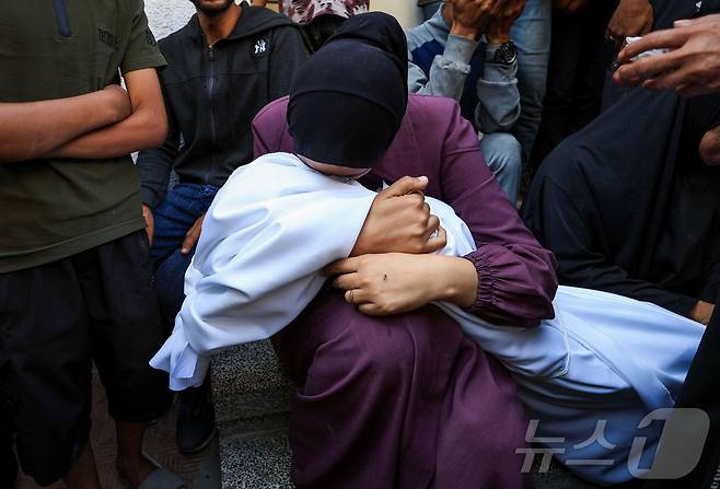 4일(현지시간) 팔레스타인 가자 시티에 있는 한 병원 장례식장에서 한 여성이 이스라엘 공격으로 숨진 이의 주검을 안고 울고 있다. 2025.06.04 ⓒ 로이터=뉴스1 ⓒ News1 최종일 선임기자