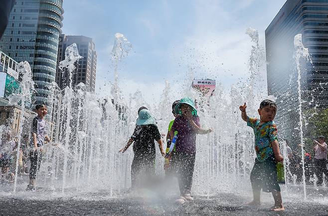 6일 오후 서울 종로구 광화문광장 분수대를 찾은 어린이들이 더위를 식히고 있다. 뉴스1