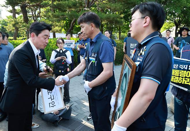 강훈식 대통령비서실장이 6일 서울 용산 대통령실 청사 인근 전쟁기념관 앞에서 태안화력발전소 사고 희생자 고(故) 김충현 씨와 관련해 엄길용 공공운수노조 위원장, 유족, 사고 대책위 관계자로부터 요구안 서한을 직접 받은 뒤 인사하고 있다. 연합뉴스