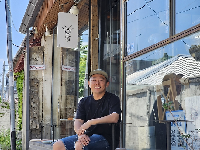 이상창 세상상회 대표가 자신의 가게 앞에서 인터뷰를 하며 활짝 웃고 있다. [이진한 기자]