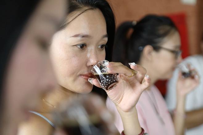 커피 향을 맡아보는 한 중국인 여행객 [사진 출처 = 신화통신 연합뉴스]