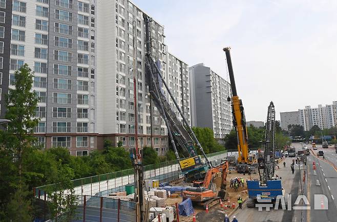 [용인=뉴시스] 김종택 기자 = 6일 경기 용인시 기흥구 서천동 인덕원~동탄 복선전철 공사 현장에서 중장비인 천공기(지반을 뚫는 건설기계)가 15층 높이 아파트 벽면에 기댄 모습으로 쓰러져 있다. 2025.06.06. jtk@newsis.com