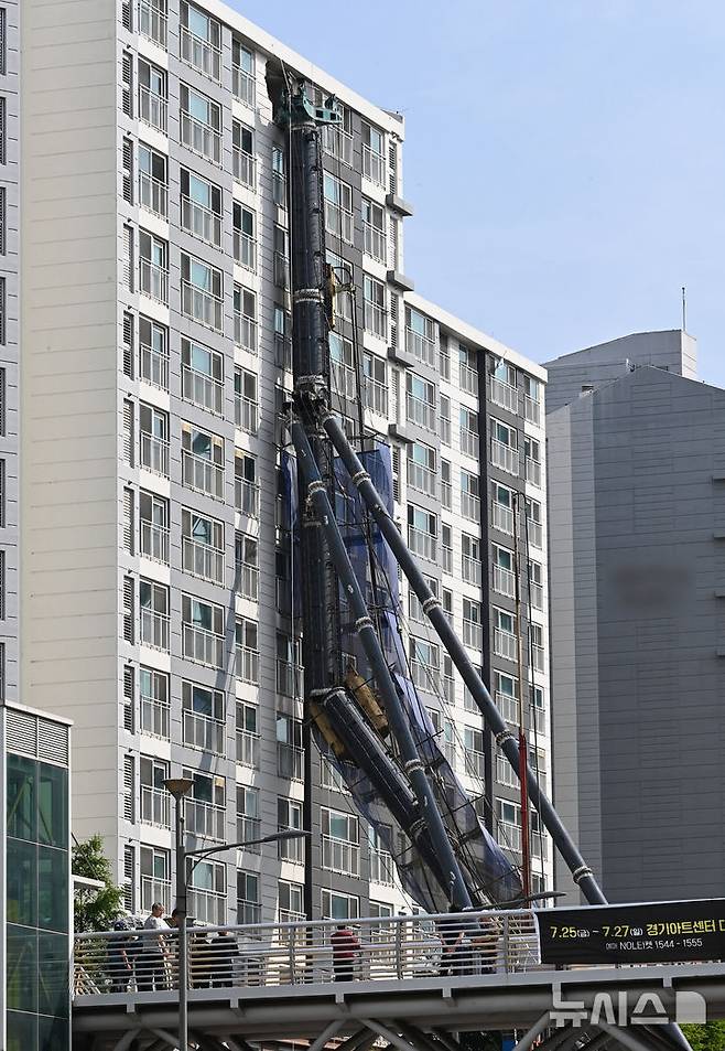 [용인=뉴시스] 김종택 기자 = 6일 경기 용인시 기흥구 서천동 인덕원~동탄 복선전철 공사 현장에서 중장비인 천공기(지반을 뚫는 건설기계)가 15층 높이 아파트 벽면에 기댄 모습으로 쓰러져 있다. 2025.06.06. jtk@newsis.com