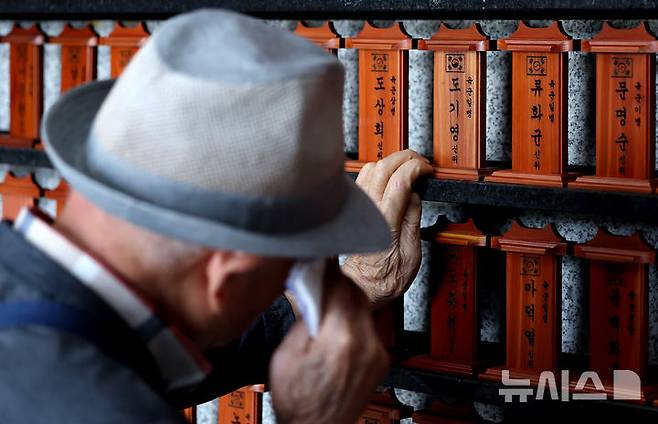 [대구=뉴시스] 이무열 기자 = 제70회 현충일인 6일 대구 남구 충혼탑 위패봉안실에서 한 참배객이 눈물을 닦고 있다. 2025.06.06. lmy@newsis.com