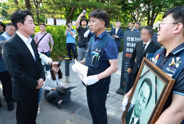 강훈식(왼쪽) 대통령비서실장이 6일 서울 용산 대통령실 청사 인근 전쟁기념관 앞에서 태안화력발전소 사고 희생자 고(故) 김충현 씨와 관련해 엄길용 공공운수노조 위원장, 유족, 사고 대책위 관계자로부터 요구 서한을 받기 앞서 대화하고 있다. 연합뉴스