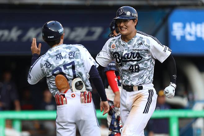 두산 김동준(오른쪽)이 6일 잠실구장에서 열린 롯데와 홈경기 6회말 우월 솔로포로 데뷔 첫 홈런을 신고한 뒤 김재현 코치와 기쁨을 나누고 있다. 사진제공｜두산 베어스