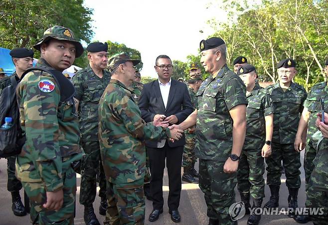 태국·캄보디아 국경 분쟁 지난달 29일(현지시간) 태국 북동부 수린주의 태국-캄보디아 국경 검문소에서 파나 끌래우플로툭 태국군 참모총장(오른쪽)과 마오 소판 캄보디아군 사령관이 만나 악수하고 있다. 
[EPA 연합뉴스 자료사진. 재판매 및 DB 금지]