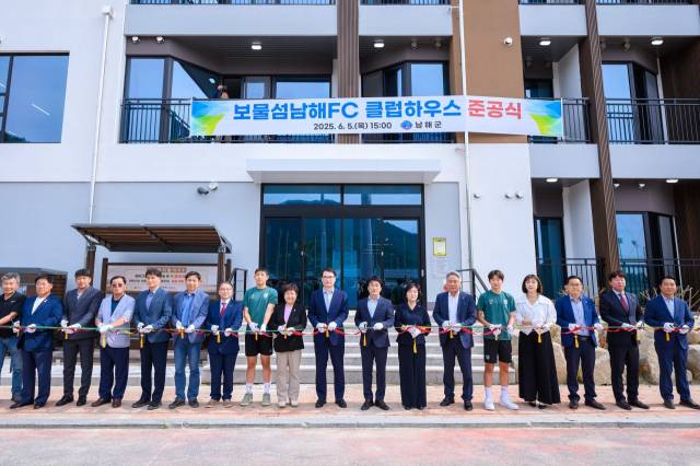 지난 5일 보물섬남해FC 클럽하우스 준공식에서 장충남 군수, 관계자, 학생 선수 등이 준공 테이프를 끊고 있다./남해군/