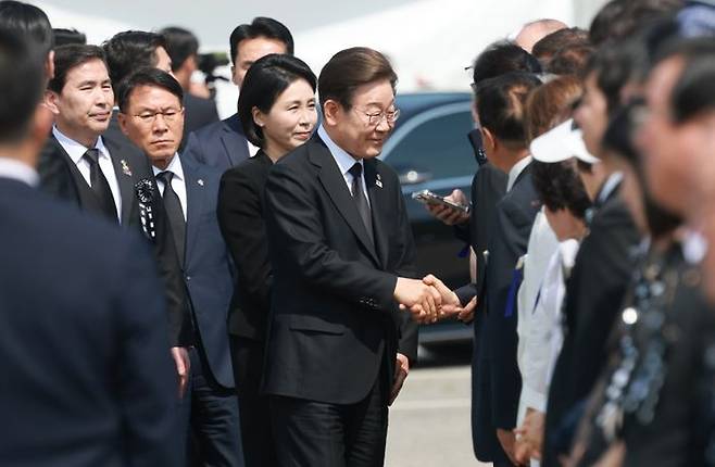 이재명 대통령과 김혜경 여사가 지난 6일 서울 동작구 국립서울현충원에서 열린 제70회 현충일 추념식에 입장하며 참석자들과 인사를 하고 있다. 김 여사 뒤는 황인권 대통령경호처장. ⓒ 뉴시스