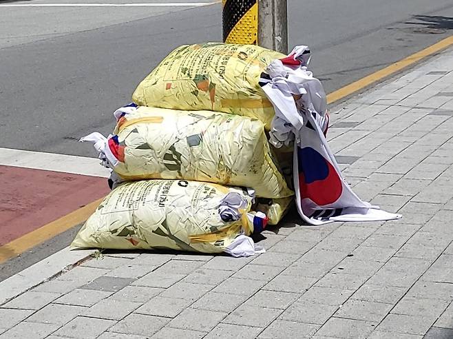 지난 6일 현충일 충북 청주 한 도로변에 태극기 더미가 쓰레기봉투에 담겨 버려져 있다. 서경덕 교수 페이스북 캡처